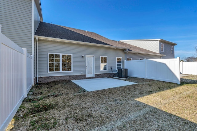 back of house with a patio area, a fenced backyard, central AC unit, and a lawn