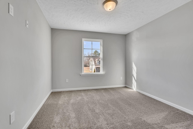 carpeted empty room featuring baseboards and a textured ceiling