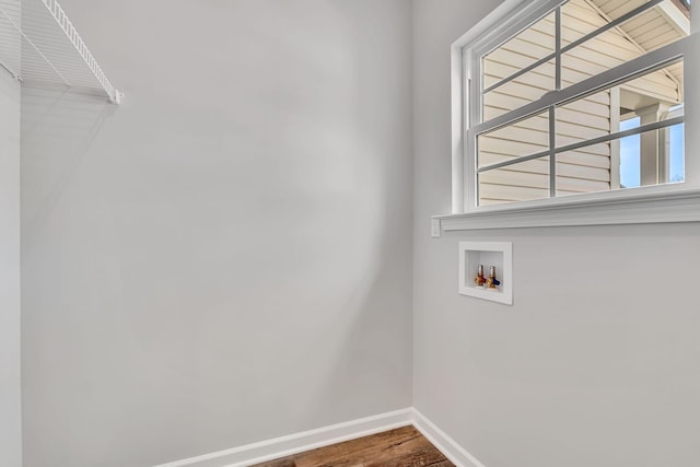 laundry area with laundry area, washer hookup, wood finished floors, and baseboards