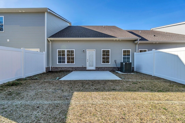 rear view of property with a patio area, a fenced backyard, a yard, and central air condition unit