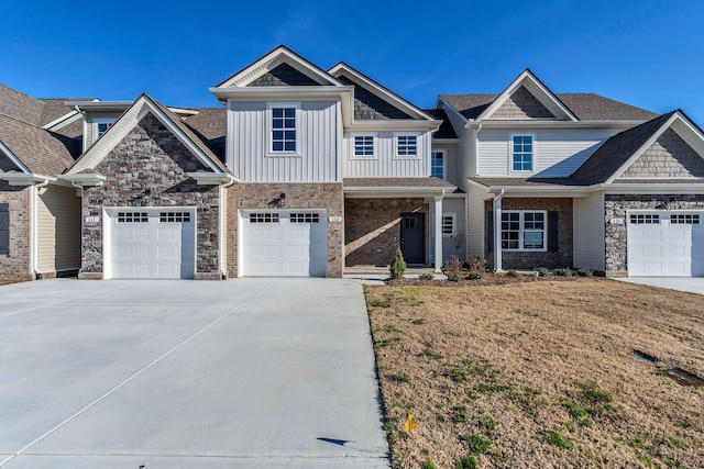 view of front of home with brick siding, concrete driveway, board and batten siding, stone siding, and a front lawn