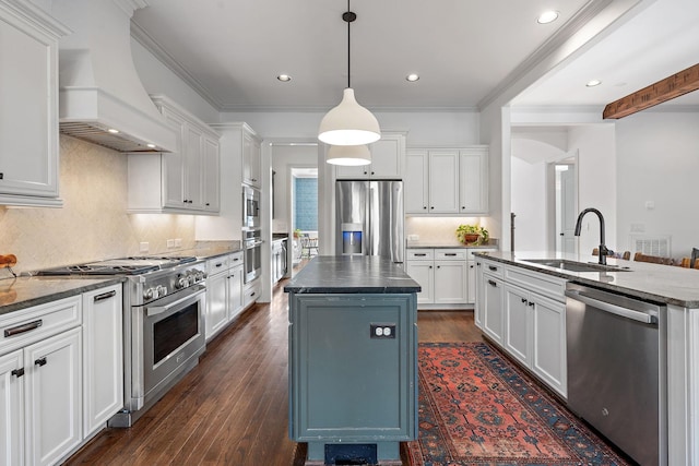 kitchen featuring stainless steel appliances, custom exhaust hood, sink, and a center island with sink