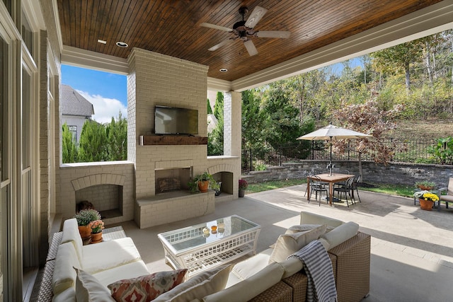 view of patio featuring ceiling fan and an outdoor living space with a fireplace