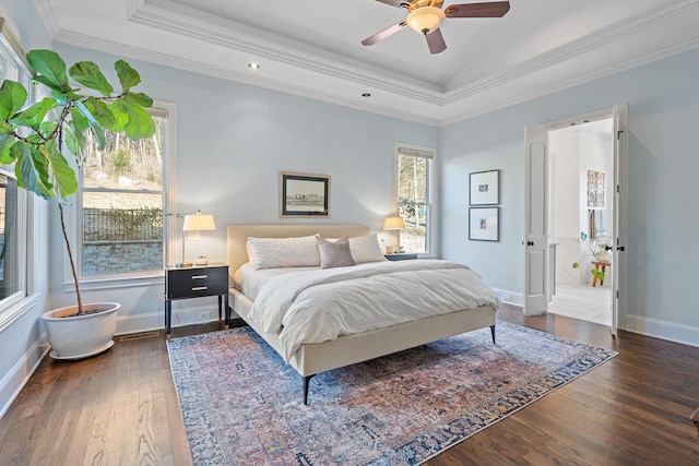 bedroom featuring lofted ceiling, ceiling fan, a tray ceiling, ornamental molding, and dark hardwood / wood-style flooring