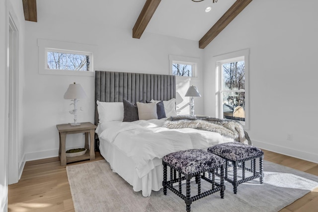 bedroom with light hardwood / wood-style flooring and vaulted ceiling with beams