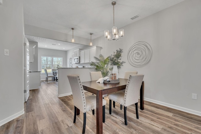 dining space featuring light hardwood / wood-style flooring and a chandelier