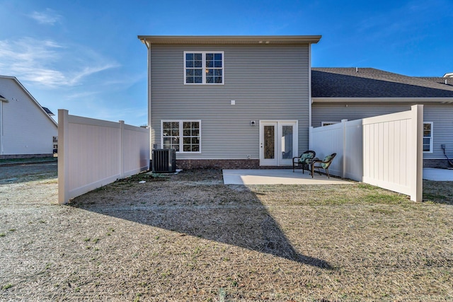 back of property featuring central AC, a lawn, and a patio area