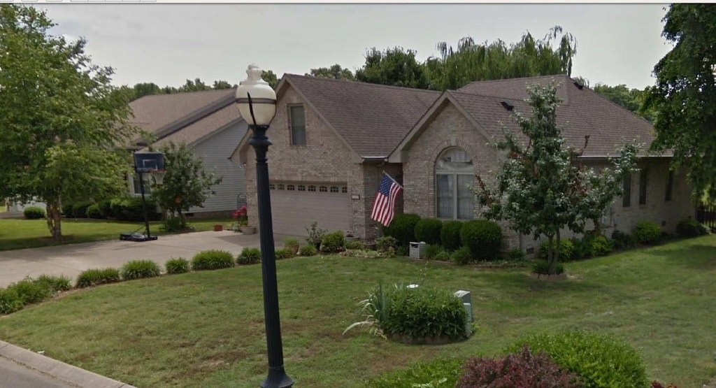 view of front of property with a garage and a front lawn