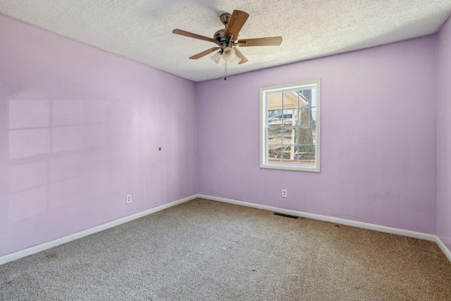 carpeted empty room featuring ceiling fan and a textured ceiling