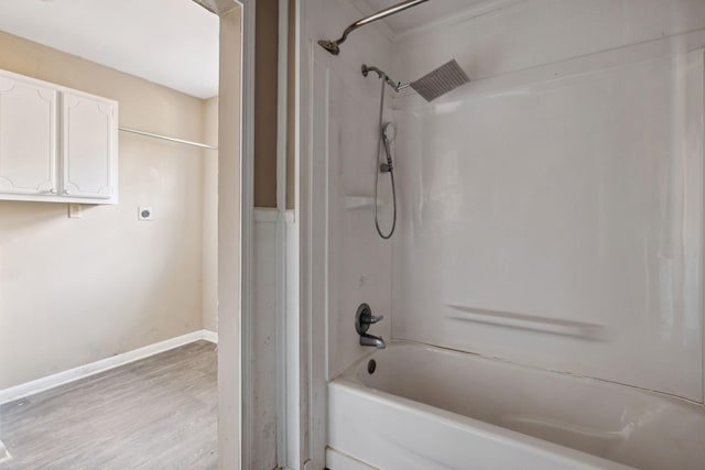 bathroom with wood-type flooring and washtub / shower combination