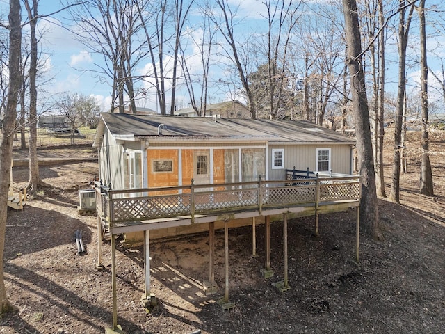 rear view of house with a wooden deck and cooling unit