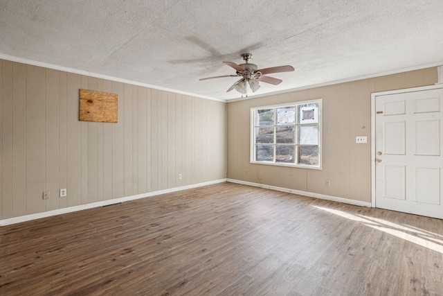 spare room with wood-type flooring, ornamental molding, ceiling fan, and a textured ceiling