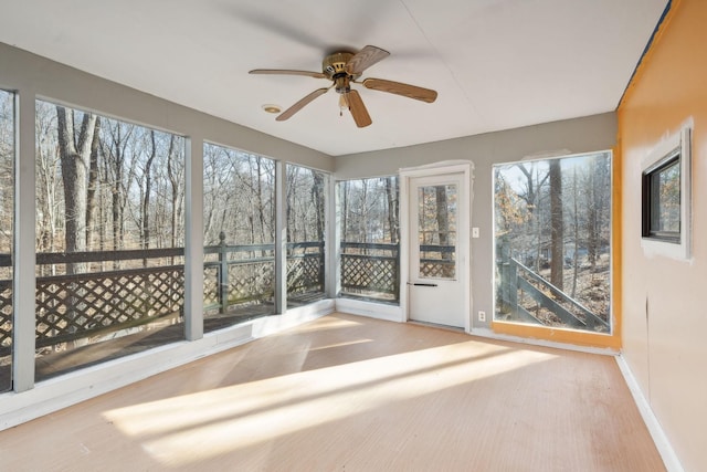 unfurnished sunroom featuring ceiling fan