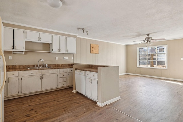 kitchen featuring white dishwasher, sink, hardwood / wood-style floors, and white cabinets