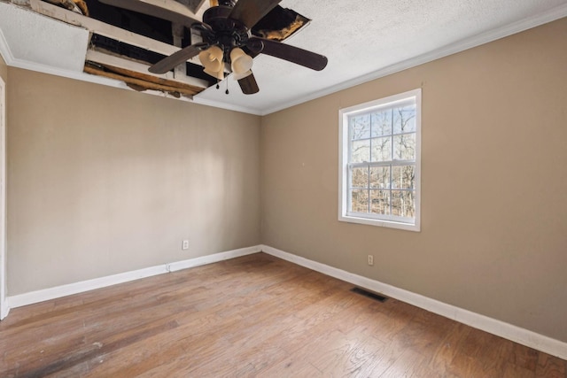 empty room featuring ornamental molding, hardwood / wood-style floors, ceiling fan, and a textured ceiling