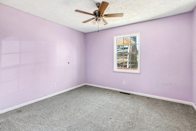 empty room with ceiling fan, carpet, and a textured ceiling