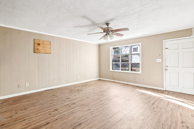 interior space featuring ceiling fan, ornamental molding, wood-type flooring, and a textured ceiling