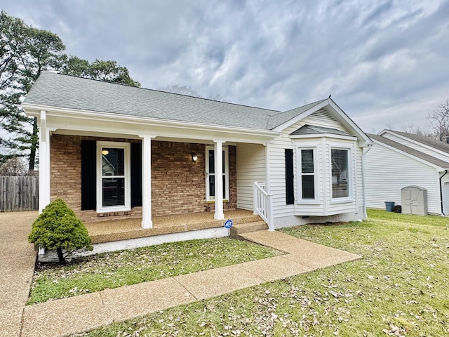 ranch-style house featuring a front yard and covered porch