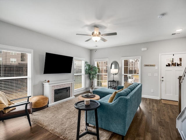 living room featuring dark wood-type flooring and ceiling fan