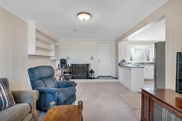 carpeted living room featuring crown molding and a brick fireplace