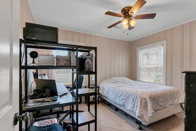 carpeted bedroom with ceiling fan and ornamental molding