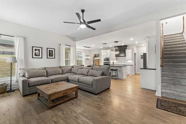 living room with wood-type flooring and ceiling fan