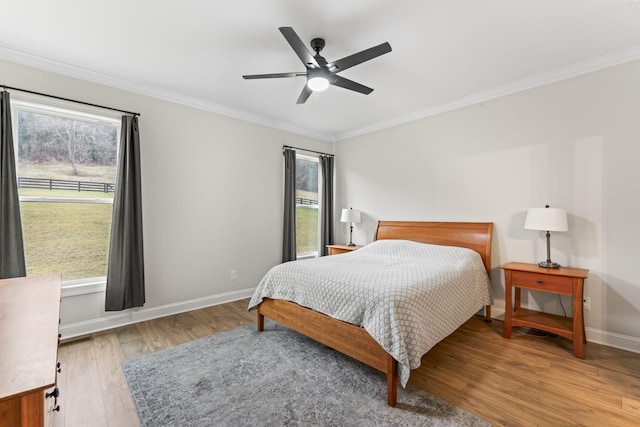 bedroom with crown molding, wood-type flooring, and ceiling fan