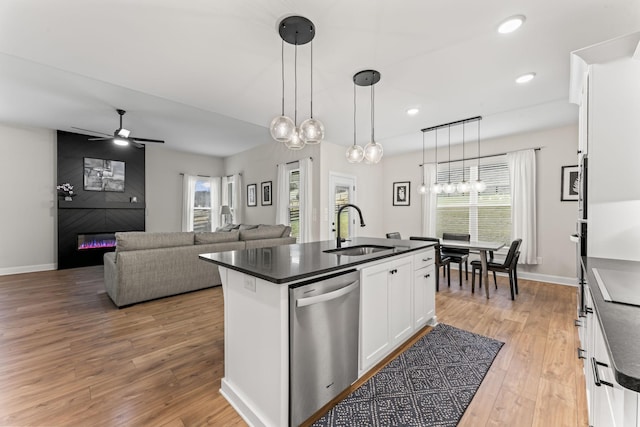 kitchen with pendant lighting, white cabinetry, sink, a kitchen island with sink, and stainless steel dishwasher