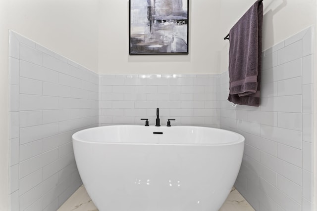 bathroom with tile walls and a bathtub