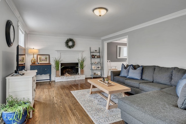 living room featuring crown molding, hardwood / wood-style floors, and a fireplace