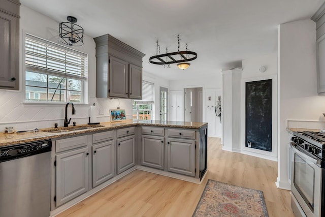 kitchen with sink, gray cabinets, stainless steel appliances, tasteful backsplash, and light hardwood / wood-style floors