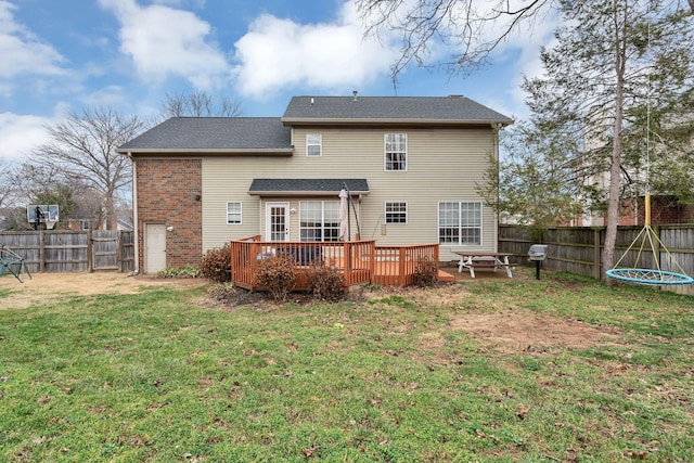 rear view of property featuring a deck and a lawn