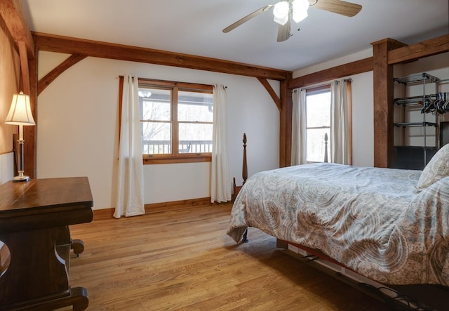 bedroom featuring baseboards, ceiling fan, and light wood-style floors