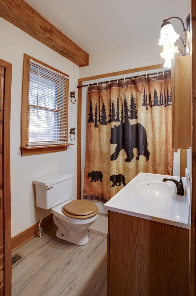 full bathroom with vanity, toilet, visible vents, beam ceiling, and wood finished floors