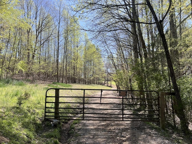 view of gate with a view of trees