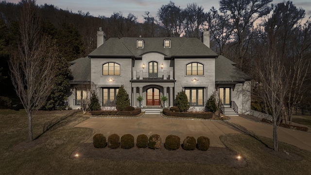 french country inspired facade with french doors and a balcony