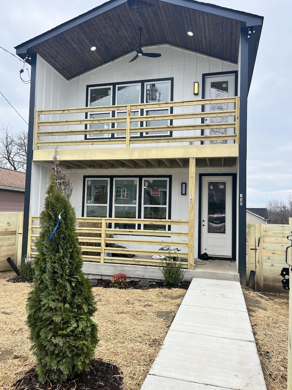 view of front of property featuring ceiling fan and a balcony