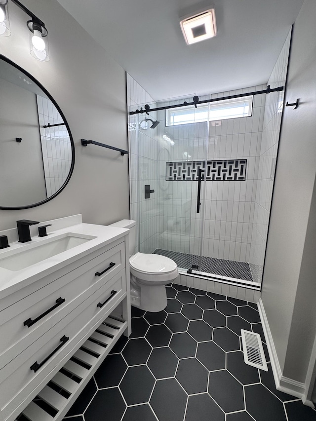 bathroom with a shower with door, vanity, and toilet