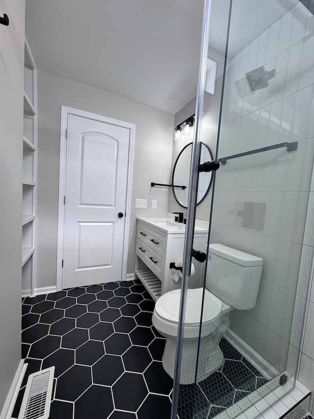 bathroom featuring vanity, a tile shower, and toilet