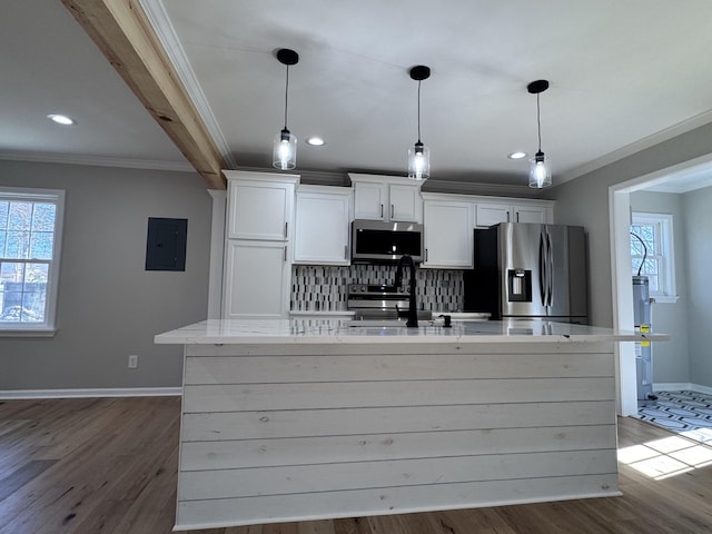 kitchen featuring stainless steel appliances, white cabinetry, a kitchen island with sink, and decorative light fixtures