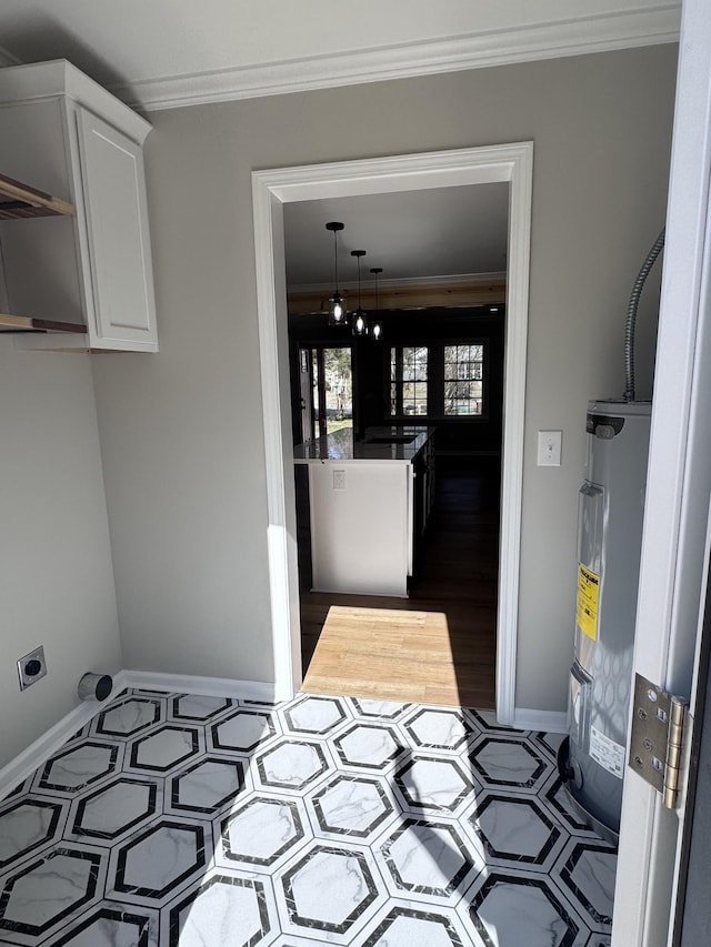 laundry room with ornamental molding and electric water heater