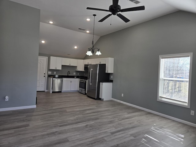 kitchen with decorative light fixtures, hardwood / wood-style flooring, stainless steel appliances, ceiling fan with notable chandelier, and white cabinets