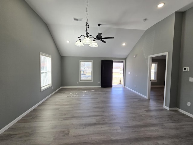 empty room with hardwood / wood-style flooring, high vaulted ceiling, and a notable chandelier