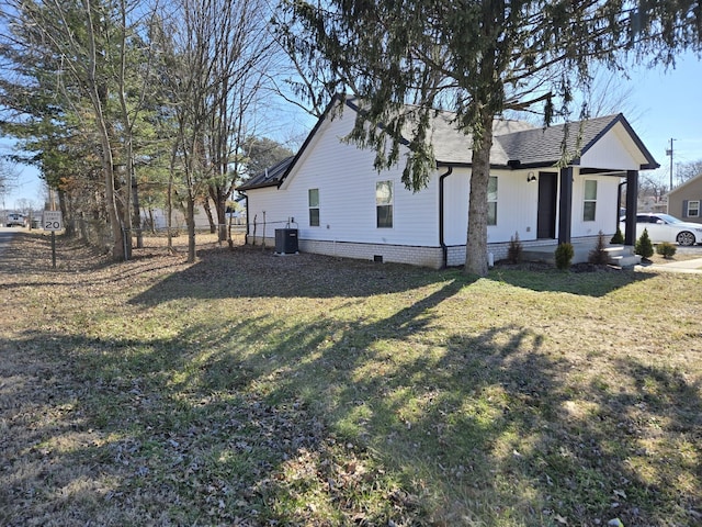 view of side of home featuring central AC unit and a lawn