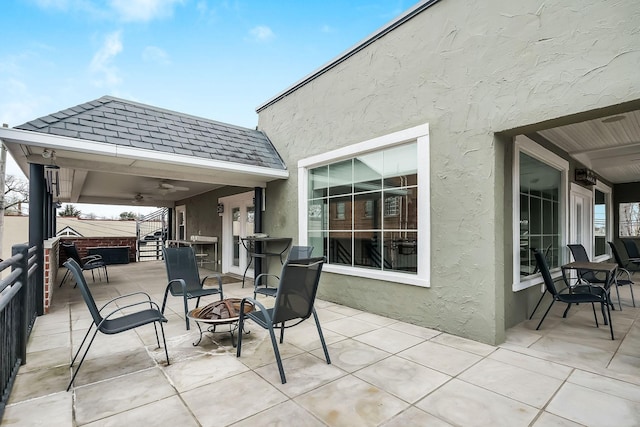 view of patio featuring ceiling fan and an outdoor fire pit