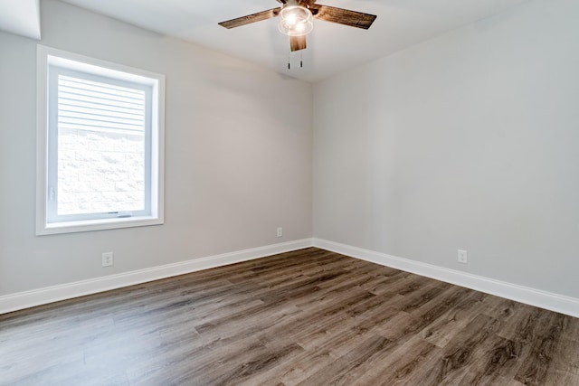 empty room featuring dark wood-type flooring and ceiling fan