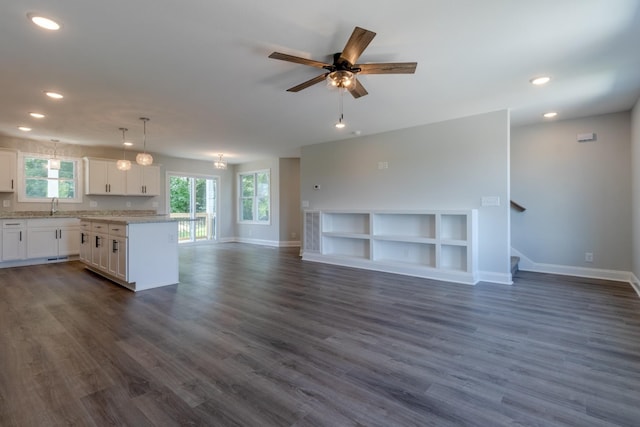 kitchen with white cabinetry, sink, pendant lighting, and dark wood-type flooring