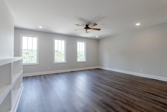 unfurnished room featuring ceiling fan, plenty of natural light, and dark hardwood / wood-style flooring