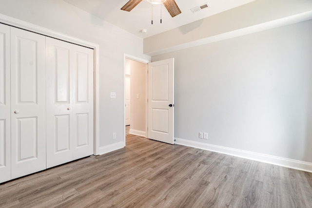 unfurnished bedroom with ceiling fan, a closet, and light hardwood / wood-style flooring