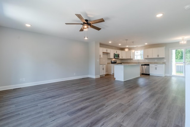 unfurnished living room featuring ceiling fan, wood-type flooring, and sink